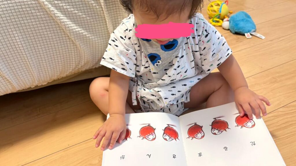 １歳児が絵本を読んでいる写真