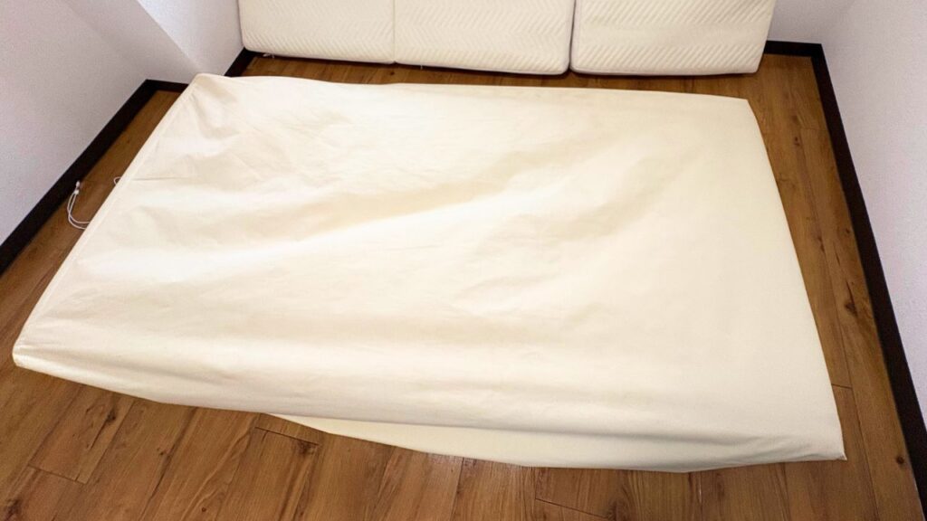 三つ折りマットレスに防水シーツを被せている画像
